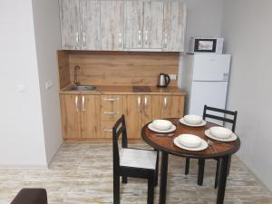 a kitchen with a table and chairs and a refrigerator at Silver Star Apartment 40m in Uzhhorod +8 photos