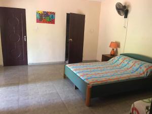 um quarto com uma cama, 2 portas e uma ventoinha em The Gunjur Project Lodge em Gunjur