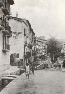Un homme marchant dans une rue sur une vieille photo dans l'établissement Hostal Victor, à Oliana