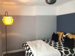 a bedroom with a black and white bed and a lamp at Cosy home close to Bangor in Bangor