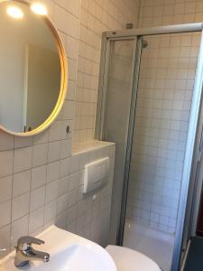 ein Bad mit einer Dusche, einem Waschbecken und einem Spiegel in der Unterkunft Ferienwohnung Huttenstraße Halle in Halle an der Saale