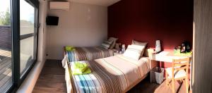 a room with two beds and a desk and a window at B&B Smile@life in Werchter