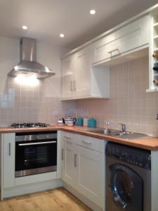 a kitchen with white cabinets and a sink and a dishwasher at Watchet Cottage in Watchet