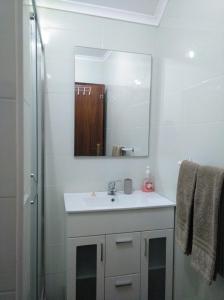 y baño con lavabo blanco y espejo. en Casa Vaz 2 en Grândola