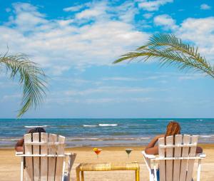 two people sitting in chairs on the beach at Kambiri Beach by Serendib in Senga