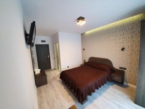 a bedroom with a bed and a dresser at Pensiunea Gaby in Cluj-Napoca