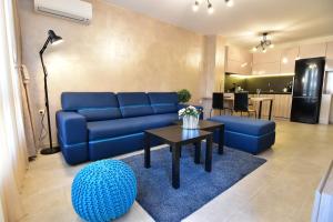 a living room with a blue couch and a table at Kapana Luxury City Center Apartments with Garage in Plovdiv