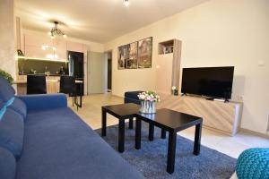 a living room with a blue couch and a table at Kapana Luxury City Center Apartments with Garage in Plovdiv
