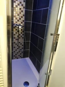 a bathroom with a shower with blue tiles at Appartement Studio Gare SNCF in Beauvais
