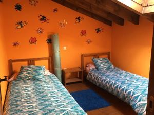 two beds sitting in a room with orange walls at CASA RURAL ANTONIO in Martiherrero