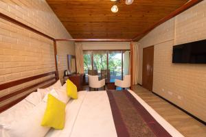 1 dormitorio con 1 cama grande con almohadas amarillas en Kambiri Beach by Serendib en Senga