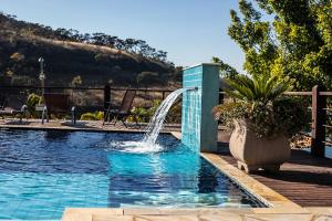 a pool with a water fountain in a yard at Pousada do Rio Turvo in Capitólio +275 photos