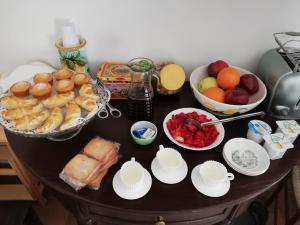 einen Tisch mit einem Haufen Essen und Schalen mit Früchten in der Unterkunft Zù Mariu B&B in Piazza Armerina
