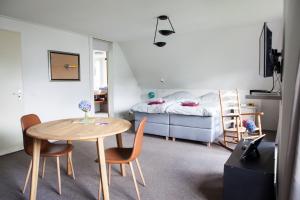 een kamer met een tafel en stoelen en een bed bij De Heidestroper in Eindhoven