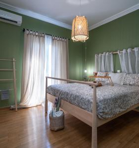 1 dormitorio con cama y pared verde en Apartment at the foothills of Acropolis, en Atenas