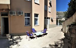4 Stühle und ein Tisch außerhalb eines Gebäudes in der Unterkunft Apartmani Stari Most in Trebinje