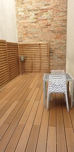 a patio with a table and a chair on a wooden floor at La maison de toujours in La Garenne-Colombes