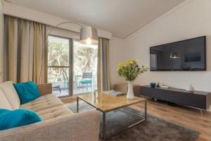 a living room with a couch and a tv at Blue&Greens Apartment in Quinta do Lago