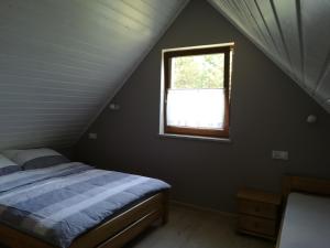 un dormitorio con una cama y una ventana en Domek u Beti, en Wąglikowice