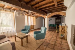sala de estar con sillas azules y mesa en Casa Rural el Rincón de Monfragüe, en Malpartida de Plasencia