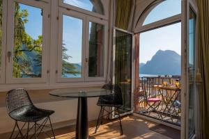 Zimmer mit Fenstern, einem Tisch und Stühlen in der Unterkunft Romantic Bijou in Lugano