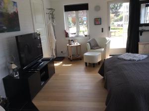 una camera con letto, TV e sedia di Langø Overnatning a Langø