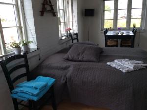 una camera da letto con un letto, un tavolo e finestre di Langø Overnatning a Langø