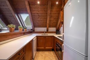 a kitchen with wooden cabinets and a refrigerator at TAMARRO de Alma de Nieve in Baqueira-Beret