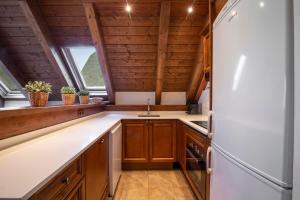 a kitchen with wooden cabinets and a refrigerator at TAMARRO de Alma de Nieve in Baqueira-Beret