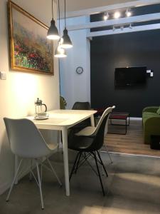 a dining room with a table and chairs and a tv at Klimatyczny apartament przy bocheńskim Rynku. in Bochnia