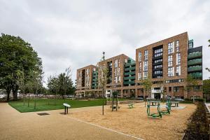 a park with a playground in front of a building at Chiswick Park Apartments London in London