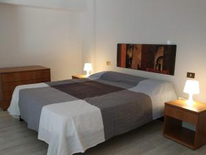 a bedroom with a large bed with two night stands at Marina Blu Rooms in Castellammare del Golfo