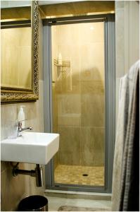 une salle de bain avec un lavabo et une douche dans l'établissement Villa Rose Cottages, à Bloemfontein