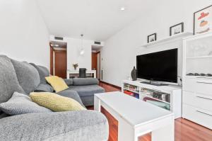 een woonkamer met een bank en een tv bij Barcelona-Forum Apartments in Barcelona