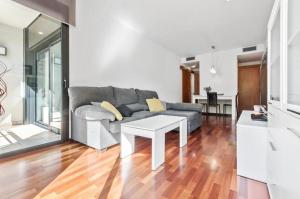 een woonkamer met een bank en een tafel bij Barcelona-Forum Apartments in Barcelona