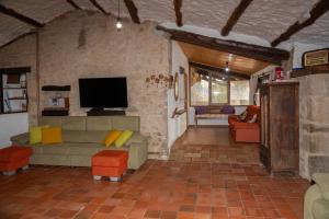 sala de estar con sofá y TV en Casa rural Sant Grau turismo saludable y responsable en Solsona