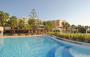 - une piscine dans un complexe avec des tables et des chaises dans l'établissement Pestana Viking Beach & SPA Resort, à Armação de Pêra