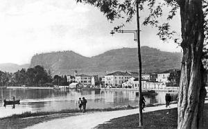 a black and white photo of people walking by a lake at Hotel Alla Riviera in Bardolino