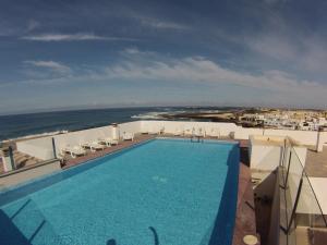 a swimming pool on top of a building with the ocean at Cotillo Ocean View in El Cotillo