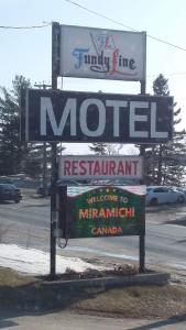 a motel sign in front of a parking lot at Fundy Line Motel in Miramichi