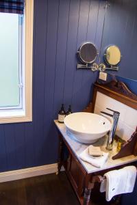 bagno con lavandino bianco e specchio di The Boat House Studio a Tairua