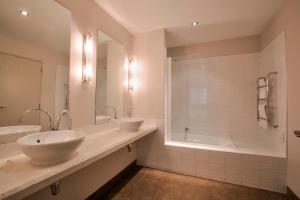 a bathroom with two sinks and a shower and a tub at Diamond Villa - Lake Views, Central Location in Queenstown