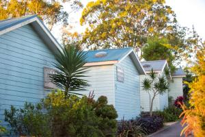 ein blaues Haus mit Bäumen im Hintergrund in der Unterkunft Thou Walla Sunset Retreat in Soldiers Point