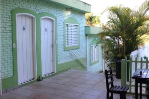 リンドーイアにあるPousada Encanto Das Aguasの緑と白のドアとパティオ付きの家