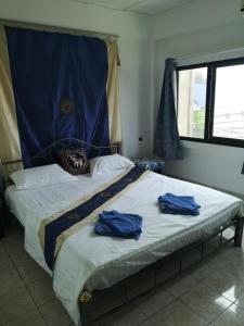 a bedroom with a bed with blue robes on it at Bellmans Restaurant & Guesthouse in Karon Beach