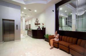 a woman sitting on a couch in a lobby at Hotel Plaza Chihuahua in Chihuahua