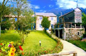 una casa con un jardín con flores delante en Casa Perfeuto Maria, en Cabana Moura 