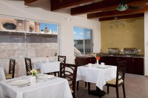 a restaurant with two tables with white table cloth at Hotel Plaza Chihuahua in Chihuahua