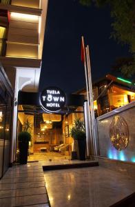 a building with a sign that reads turn to wow night at Tuzla Town Hotel in Tuzla