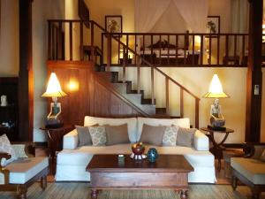 a living room with a white couch and a staircase at Ibah in Ubud